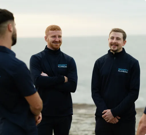 Three of the team by the water between jobs